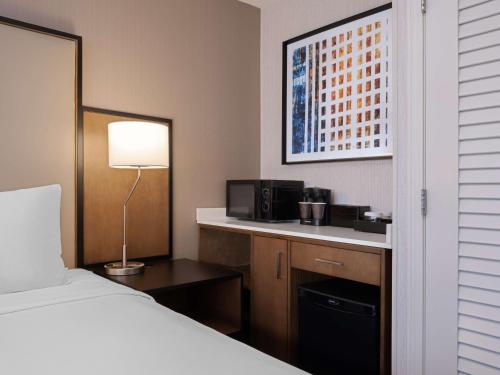 a hotel room with a bed and a microwave at Embassy Suites Chicago - Downtown River North in Chicago