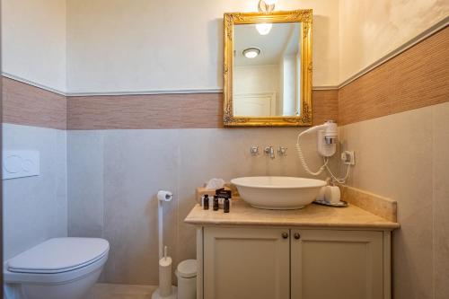 bagno con lavandino, servizi igienici e specchio di Relais Colle San Pietro a Verona