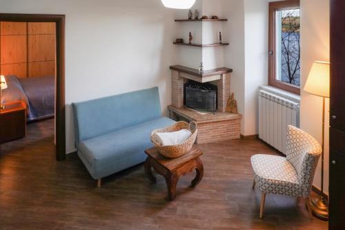 sala de estar con sofá azul y chimenea en Le Rupi - Apartment en Anguillara Sabazia