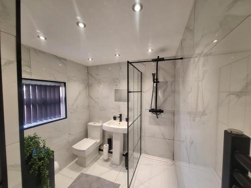 a bathroom with a shower and a toilet and a sink at Large family house in Liverpool