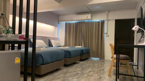 a bedroom with a bed with blue sheets and a chair at Jeboutiquelangsuan hotel in Lang Suan