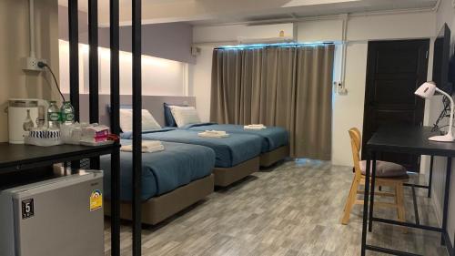 a bedroom with a bed and a table and a chair at Jeboutiquelangsuan hotel in Lang Suan