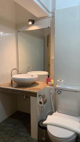a bathroom with a sink and a toilet and a mirror at Jeboutiquelangsuan hotel in Lang Suan