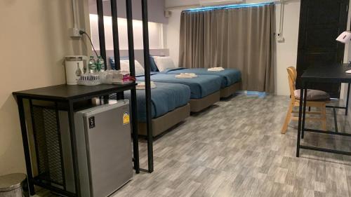 a bedroom with a bed and a table and a desk at Jeboutiquelangsuan hotel in Lang Suan
