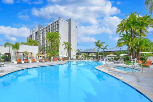 a large swimming pool with a hotel in the background at Hilton Irvine/Orange County Airport in Irvine