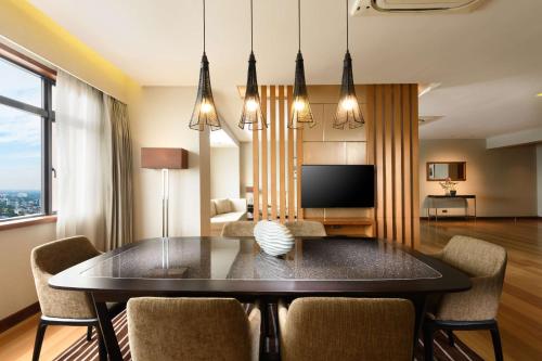 a dining room with a table and chairs at Hilton Colombo Residence in Colombo