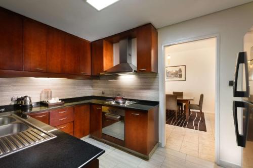a kitchen with wooden cabinets and a stove top oven at Hilton Colombo Residence in Colombo