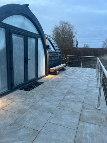 an outside view of a glass house with a deck at The Pod @ Cold Comfort Farm in Hinckley