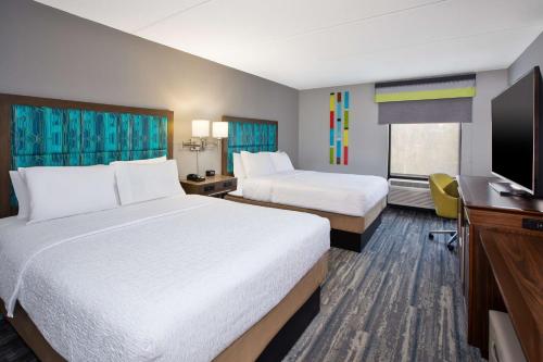 Habitación de hotel con 2 camas y TV de pantalla plana. en Hampton Inn Daytona/Ormond Beach, en Ormond Beach