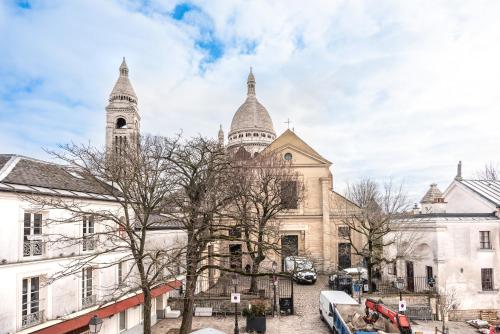 an old building with two towers on a city street at Maison La Bohème Montmartre - Studios & Apartments in Paris