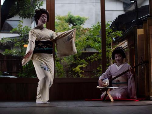 a man in kimono standing on a stage next to a boy at Hyatt Centric Kanazawa in Kanazawa