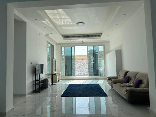 uma sala de estar com um sofá e uma grande janela em Centerpoint Duplex Villa em Dubai