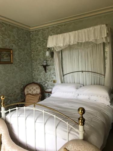 um quarto com uma cama de dossel branca em st marys mount em Ulverston