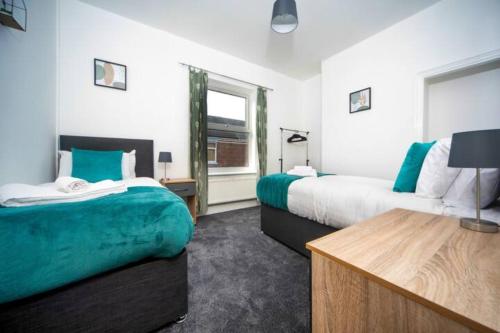 a hotel room with two beds and a window at Cosy 3-Bedroom Willow House in Selby