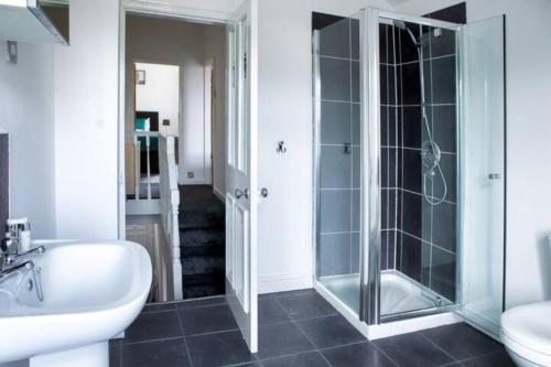 La salle de bains est pourvue d'une douche en verre et d'un lavabo. dans l'établissement Cosy Three Bedroom Willow House, à Selby