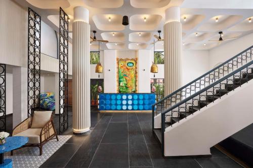 vestíbulo con columnas y escalera con zona de estar en Ronil Goa - a JdV by Hyatt Hotel, en Calangute