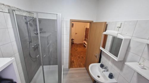 uma casa de banho com um chuveiro, um lavatório e um WC. em Nordseebude em Husum