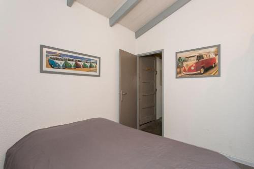 a bedroom with two framed pictures on the wall at FLAT BEHIND THE DUNE IN SEIGNOSSE (5 km hossegor) in Seignosse