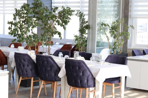a dining room with tables and chairs and windows at Cavit Duvan Prestige Hotel in Edirne
