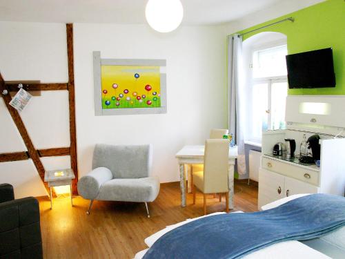 una camera con una camera da letto con un tavolo e una sedia di Boutique Hotel Little Venezia a Bamberga