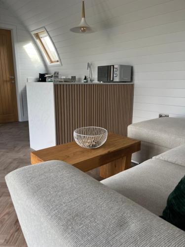 a living room with a table and a kitchen at The Pod @ Cold Comfort Farm in Hinckley