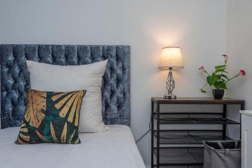 Dormitorio con cama con almohada y lámpara en Stunning 3-Bed House, en Londres