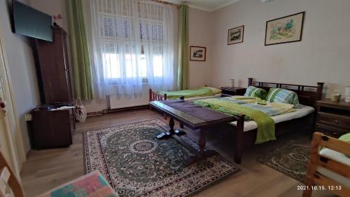 ein Schlafzimmer mit einem Bett und einem Tisch darin in der Unterkunft Vazsita ház in Erdőbénye