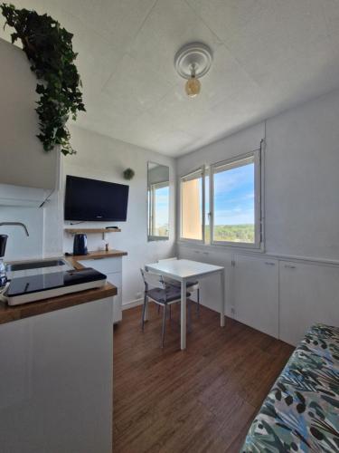 une chambre avec une table et une cuisine avec une fenêtre dans l'établissement Studio - Marina 4 - 17 allée des Pinons - 5-1, à Saint-Jean-de-Monts