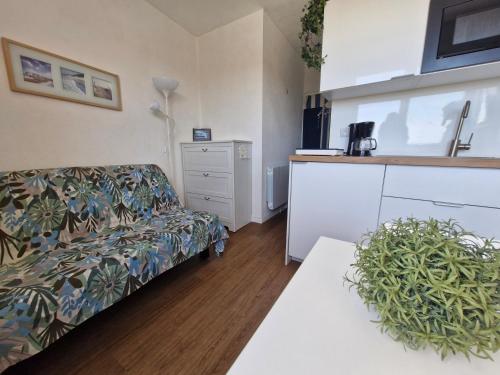 een woonkamer met een bank en een tafel bij Studio - Marina 4 - 17 allée des Pinons - 5-3 in Saint-Jean-de-Monts