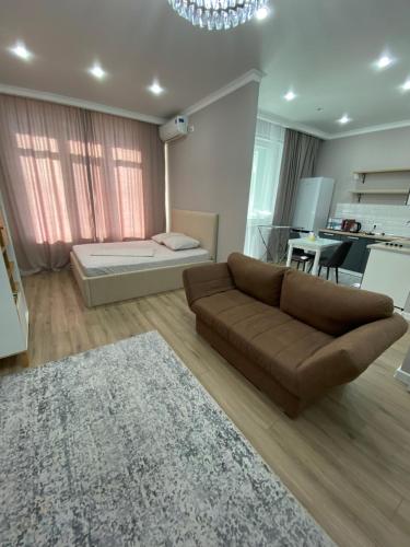 a living room with a couch and a bed at Однокомнатные бизнес апартаменты в ЖК Заман in Atyraū
