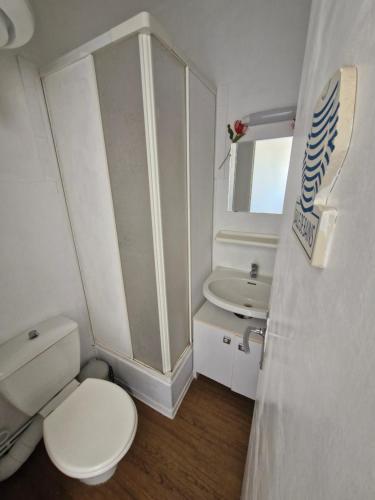 een witte badkamer met een toilet en een wastafel bij Studio - Marina 4 - 17 allée des Pinons - 5-3 in Saint-Jean-de-Monts