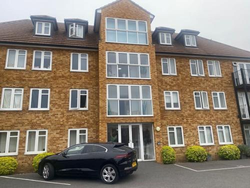a black car parked in front of a brick building at Luxury Penthouse Appartment in Cobham