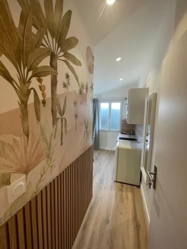 a kitchen with a mural of palm trees on the wall at Maison Meire Studios in Cognac