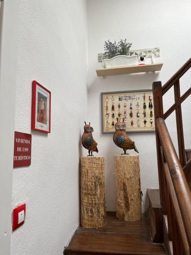 dwa ptaki siedzące na kłodach w klatce schodowej w obiekcie La casita de mi abuela w mieście Santo Domingo de la Calzada