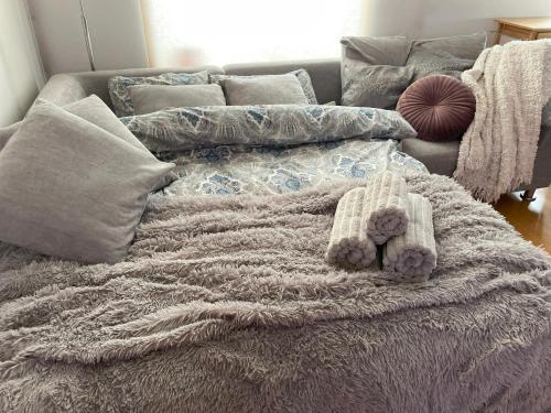 een bed met een deken en een teddybeer erop bij Kunderi apartment with sauna in Rakvere