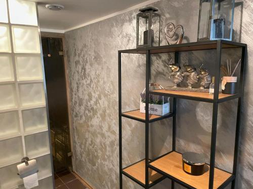 a black shelf with items on it in a room at Kunderi apartment with sauna in Rakvere