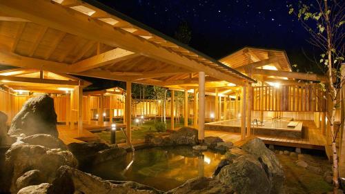 una casa de madera con un estanque en el patio en ANA Crowne Plaza Resort Appi Kogen, an IHG Hotel, en Hachimantai