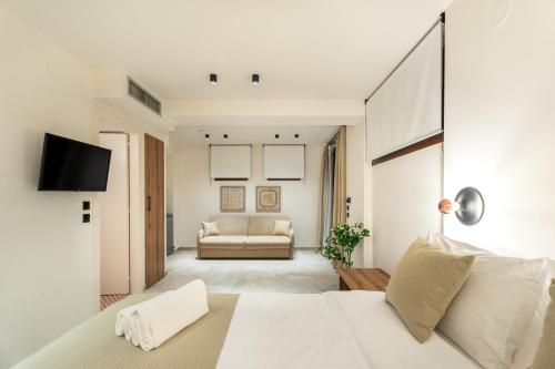 1 dormitorio con cama blanca y sofá en Mpikas Holidays, en Ierissos