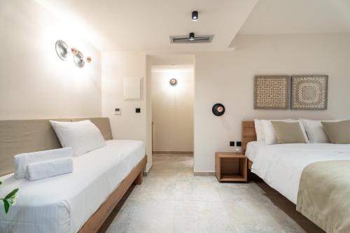 two beds in a room with white walls at Mpikas Holidays in Ierissos
