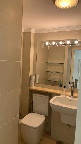 a bathroom with a toilet and a sink and a mirror at Sol y Sea Holiday Homes Don Paco in Patalavaca