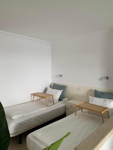 two beds in a room with two tables at Sol y Sea Holiday Homes Don Paco in Patalavaca