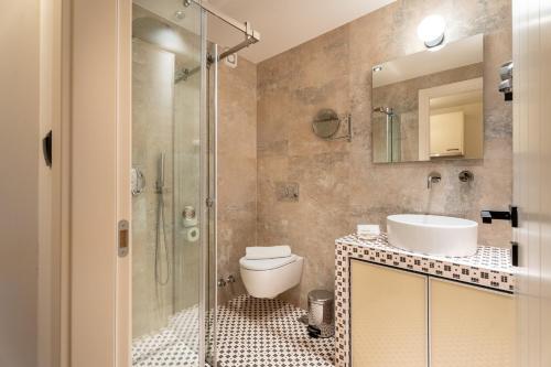 a bathroom with a shower and a toilet and a sink at Mpikas Holidays in Ierissos