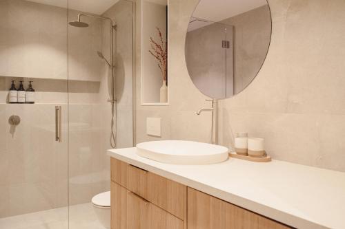 a bathroom with a sink and a shower with a mirror at Urban oasis with sauna in Wellington