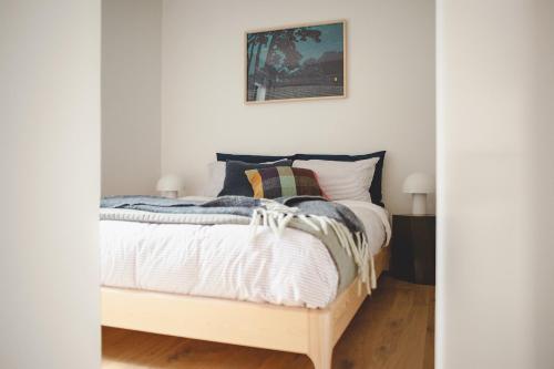 1 dormitorio con 1 cama con sábanas blancas en Urban oasis with sauna en Wellington