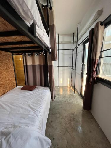 1 dormitorio con litera y ventana grande en Jidjai hostel en Chiang Rai