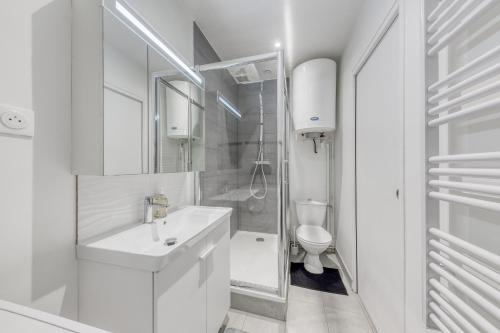 a white bathroom with a sink and a toilet at Le Boisier - 3 min de la Gare Massy TGV - Cozy Houses in Palaiseau