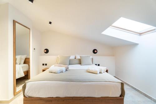 a bedroom with a large bed with a skylight at Mpikas Holidays in Ierissos
