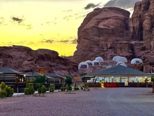 um resort no deserto com uma montanha ao fundo em Rum Oasis Luxury Camp em Wadi Rum