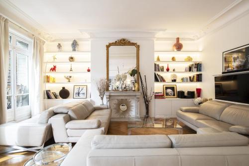 Elle comprend un salon doté d'un mobilier blanc et d'une cheminée. dans l'établissement Deluxe Paris St Germain Suite, à Paris