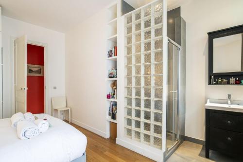 a bedroom with a bed and a sink and a mirror at Deluxe Paris St Germain Suite in Paris